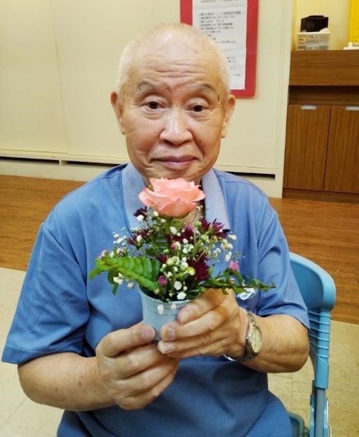 Grandpa Mao Sung is holding a flower with smile, it shows he is quite enjoy his life with Eden's accompany.