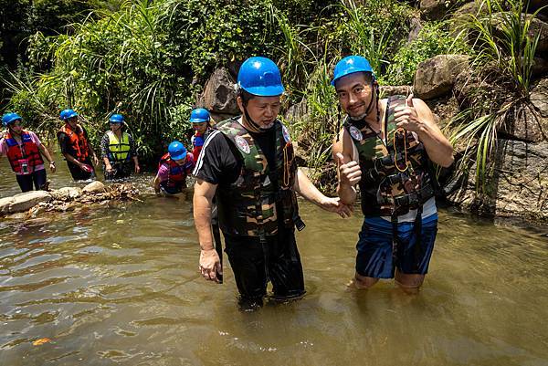 Persons with visual impairment hold the volunteer’s hand as he tried to cross the rushing stream.